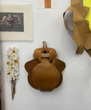 Partially worked needlepoint mesh with printed image of cutout (2020); leather and stretchers piece; resin/plaster print of needlepoint with embedded dry flowers